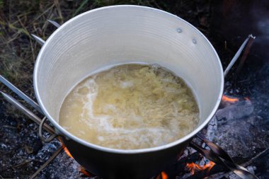 Kamp gezisinde açık bir tencerede yemek pişirmek..