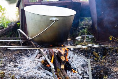 Kamp gezisinde açık bir tencerede yemek pişirmek..