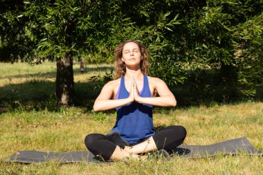 Kadın fitness eğitmeni yapar, yeşil bir parkta egzersiz yapar. Spor konsepti.