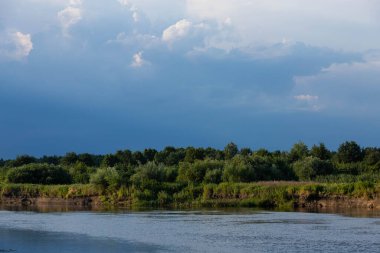 Avrupa manzarası, nehir, mavi gökyüzü yeşil ağaçlar üzerinde.