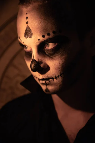 光の背景に黒いTシャツを着た男の肖像画 ハロウィーンの頭蓋骨が彼の感情を示すために構成されています ハロウィンパーティーやホラーテーマ メキシコ文化 — ストック写真
