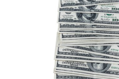 Beyaz arka planda 100 dolarlık banknotların üst görüntüsü.