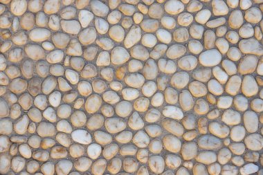 Beton yolda beyaz çakıl taşı. Üst görünüm taşı arka planı. Deniz kenarındaki çakıl taşı fotoğraf dokusu. Taş kaldırım yüzeyi. Doğal dış dekorasyon malzemesi yuvarlanmış kaldırımlar
