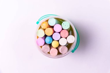 Beyaz arka planda kovadaki renkli tebeşir.