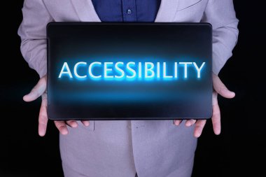 Gri takım elbiseli bir işadamı tarafından tutulan dizüstü bilgisayarında neon harflerle yazılmış bir yazı..