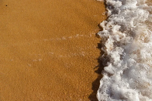 有气泡的海浪冲击着沙滩 — 图库照片