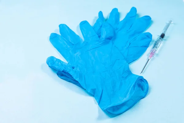Medical gloves with a syringe. Dirty medical instrumentation after the procedure.