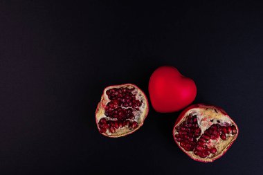 Kırık bir nar ve koyu bir arkaplanda kalp..