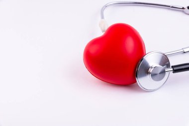 Beyaz arka planda fonendoskoplu ses ölçer kalp. Kalp hastalığı olan hastalara destek kavramı.