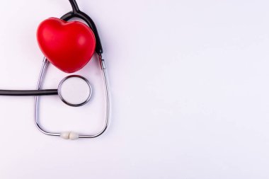 Beyaz arka planda fonendoskoplu ses ölçer kalp. Kalp hastalığı olan hastalara destek kavramı.