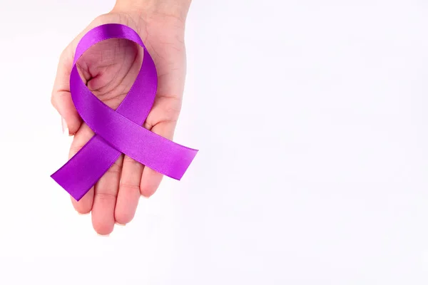 Purple ribbon in a female hand pancreatic cancer symbol with copy space.