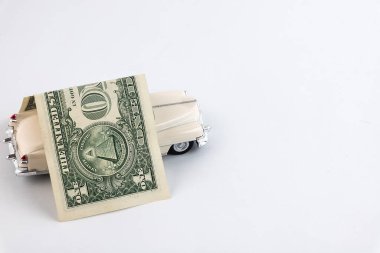 Bir dolarlık çatı beyaz araba oyuncağını kapsıyor. Araba sigortası kavramı