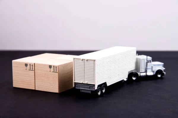 Toy truck and boxes with cargo on a black table