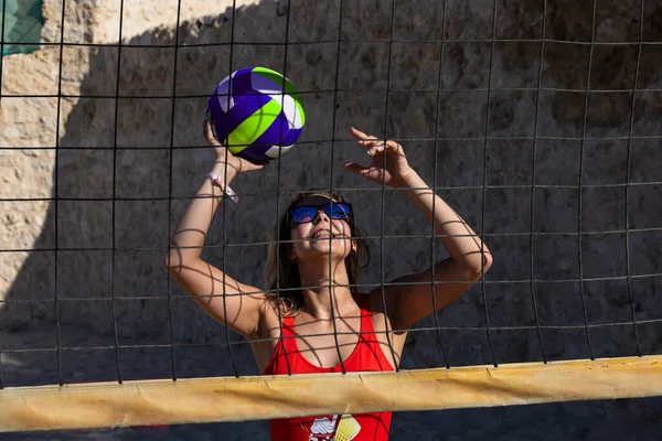 Sharm El Sheikh, Mısır - 12.25.2019: Voleybol sahasında kırmızı mayo giymiş genç bir kız. Plaj voleybolu.