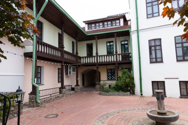 MINSK, BELARUS - 26 Ekim 2020: Şehir merkezindeki tarihi bina, balkonlu avlu ve sonbahar akçaağaçları.