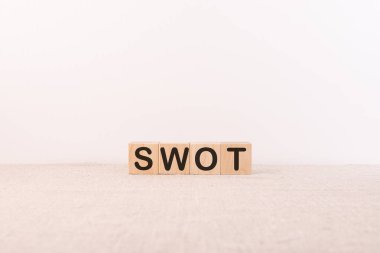 Işık arkaplanındaki yapı taşlarıyla oluşturulan SWOT kelimesi