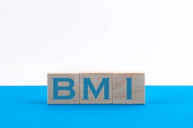 BMI vücut kütle indeksi mavi arkaplandaki tahta küplerde harf blokları