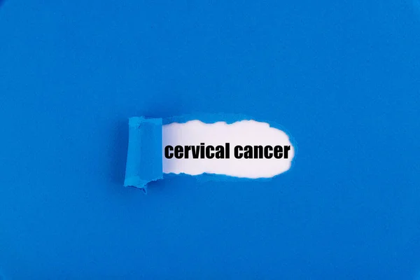 The text cervical cancer appearing behind torn blue paper.