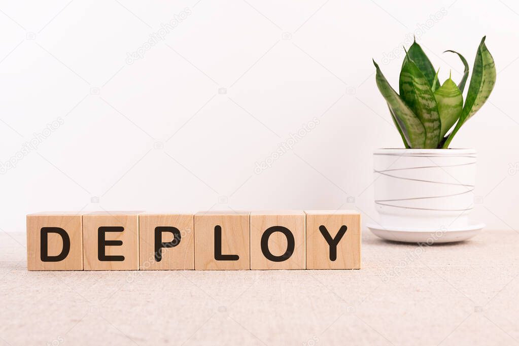 Deploy word written on wooden cubes on a white background.