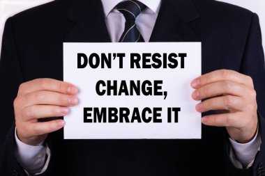 İş adamı elinde yazılı bir kart tutuyor. Değişikliğe karşı koyma. Onu kucakla.