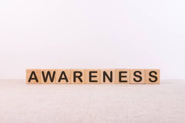 AWARENESS kelime kavramı bir ışık masası üzerinde ahşap küplere yazılmış ve hafif bir arkaplan