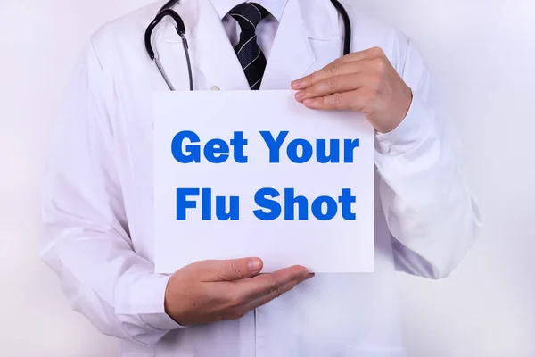 Doctor holding a card with Get Your Flu Shot, medical concept