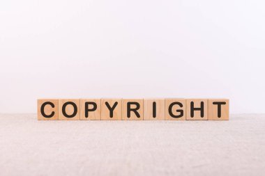 Işık arkaplanındaki yapı taşlarıyla oluşturulan telif hakkı sözcüğü
