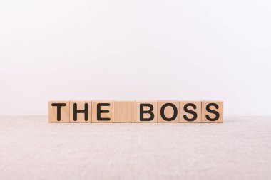 Aydınlık bir masa ve arka planda uzanan tahta küplere yazılmış Patron kelimesi konsepti.