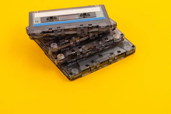 黄色の背景に80年代のレトロなオーディオカセットテープ — ストック写真