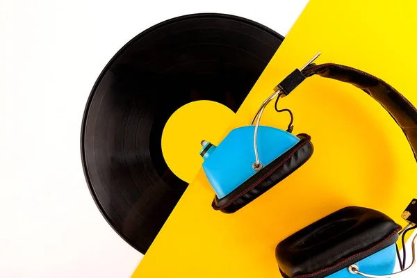 黄色の背景にビニールレコードとヘッドフォン オーディオ愛好家 音楽愛好家やプロのDj機器 — ストック写真