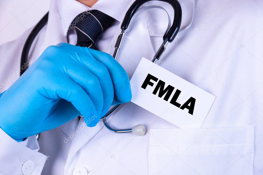 Doctor holding a card with text FMLA medical concept