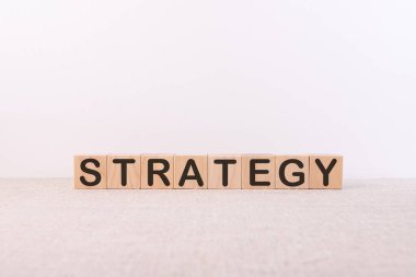 STRATEGY kelime kavramı bir ışık masasında duran tahta küpler üzerine yazılmış ve ışık arka plan.