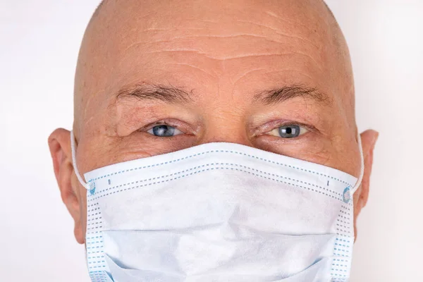 A sick man in a medical mask stands on a white background. The concept of protection against viral infection.