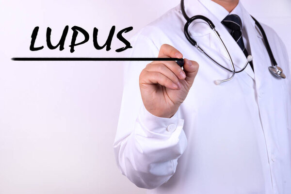Doctor writing word Lupus with marker Medical concept
