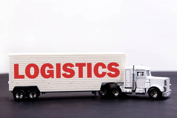 Logistics word concept written on board a lorry trailer on a dark table and light background