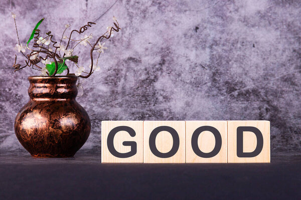 Word GOOD made with wood building blocks on a gray back ground