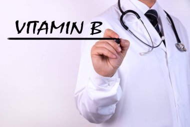 Doktor, B Vitamini 'ni işaretleyici tıbbi konseptle yazıyor.