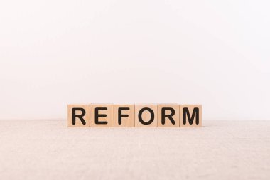 Metin, kelime reformu ahşap yapı taşlarına, hafif bir zemine yazılmış. İş konsepti