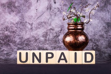 Kelime UnPAID gri bir arka planda ahşap yapı taşları ile yapılmış