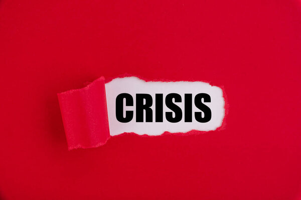 Текст CRISIS появляется за рваной красной бумагой.