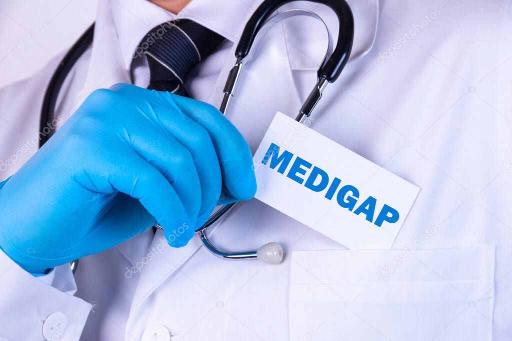 Doctor, man put a card with the text MEDIGAP in his pocket. Medical concept.
