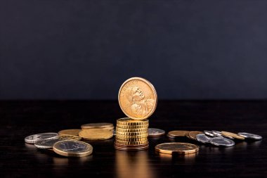 Bozuk para kulesine, karanlık bir masanın üstüne bir dolar. İş konsepti. Sembol.