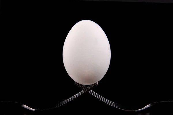 Yumurta Çatalların Üzerinde Koyu Bir Arka Planla Dengelenmiştir Minimalizm — Stok fotoğraf