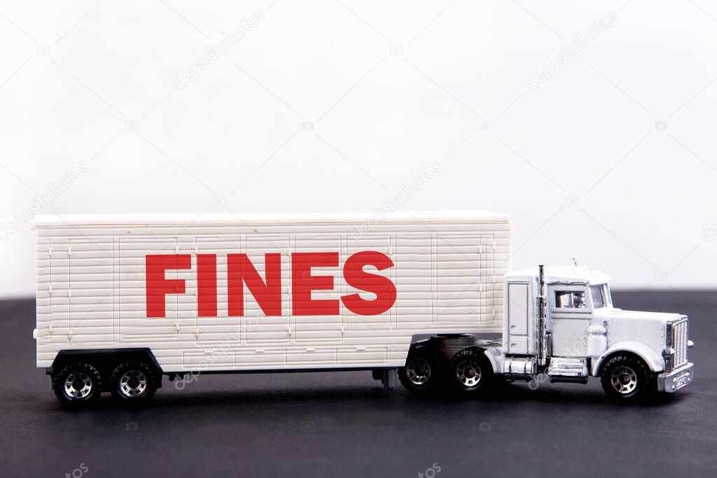 Fines word concept written on board a lorry trailer on a dark table and light background