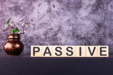 Kelime PASSIVE gri arka planda ahşap yapı taşları ile yapılmış