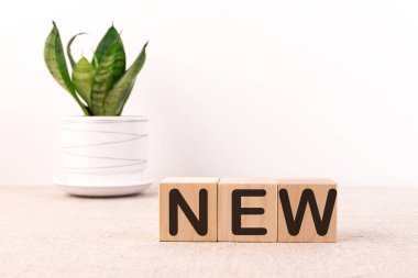 Beyaz masada, yeni sözcüğü olan üç tahta küp.