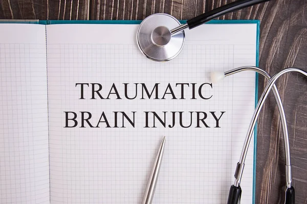 Notebookpagina Met Tekst Traumatische Brain Injuri Een Tafel Met Stethoscoop — Stockfoto
