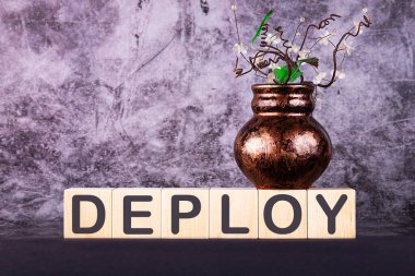 Kelime DEPLOY gri bir zemin üzerinde ahşap yapı taşları ile yapılmış
