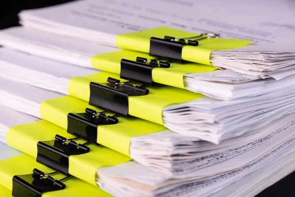 Pile of documents with black clips Clamped stacked on the desk in the office.