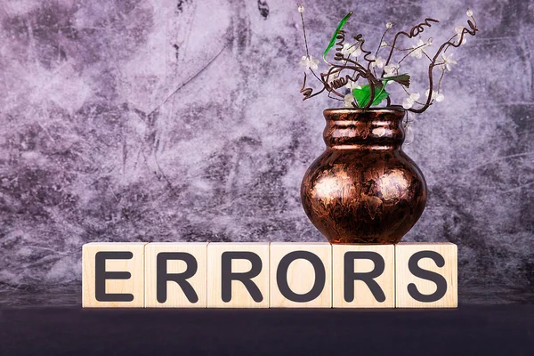 Kelime ERRORS gri arka planda ahşap yapı taşları ile yapılır.